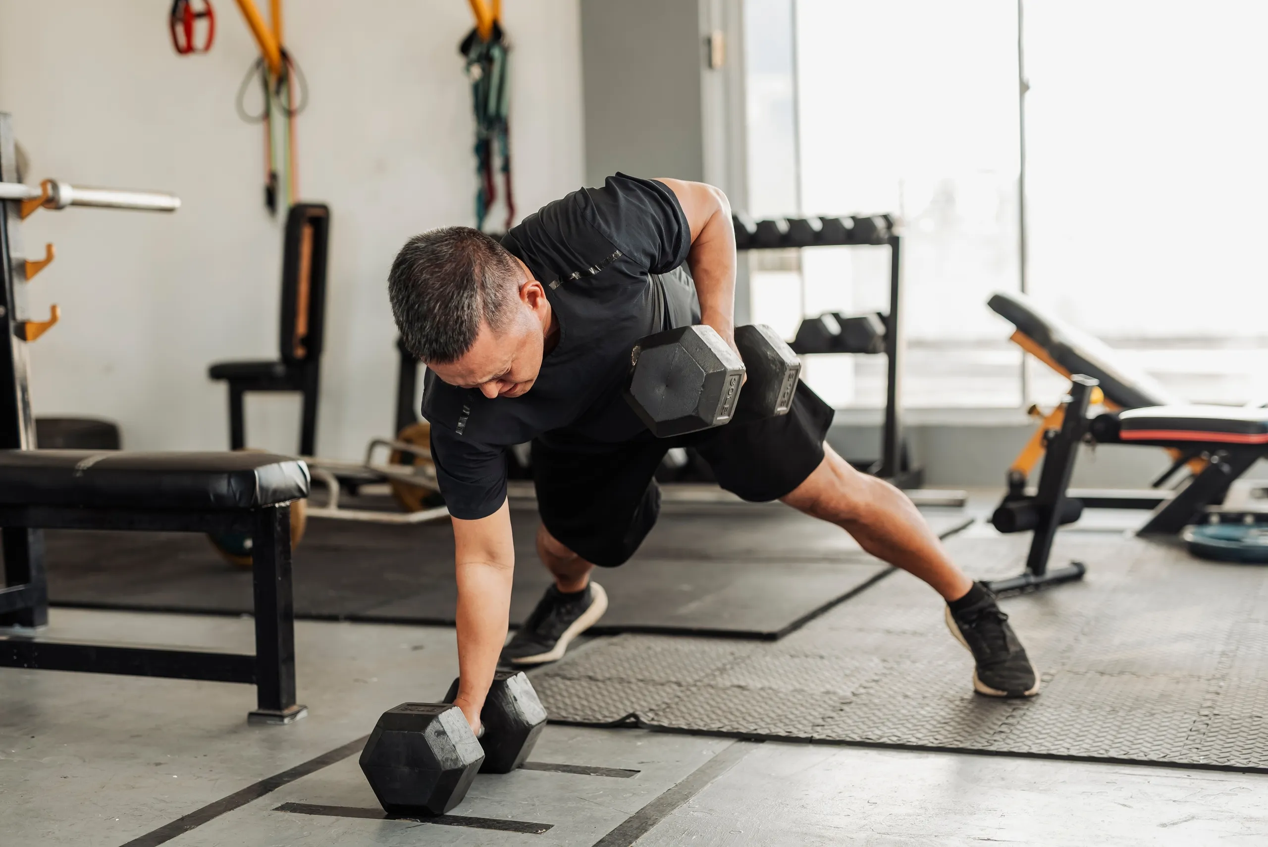 Tập luyện sức mạnh với tạ đơn: Nam tập động tác Renegade Row trong phòng gym